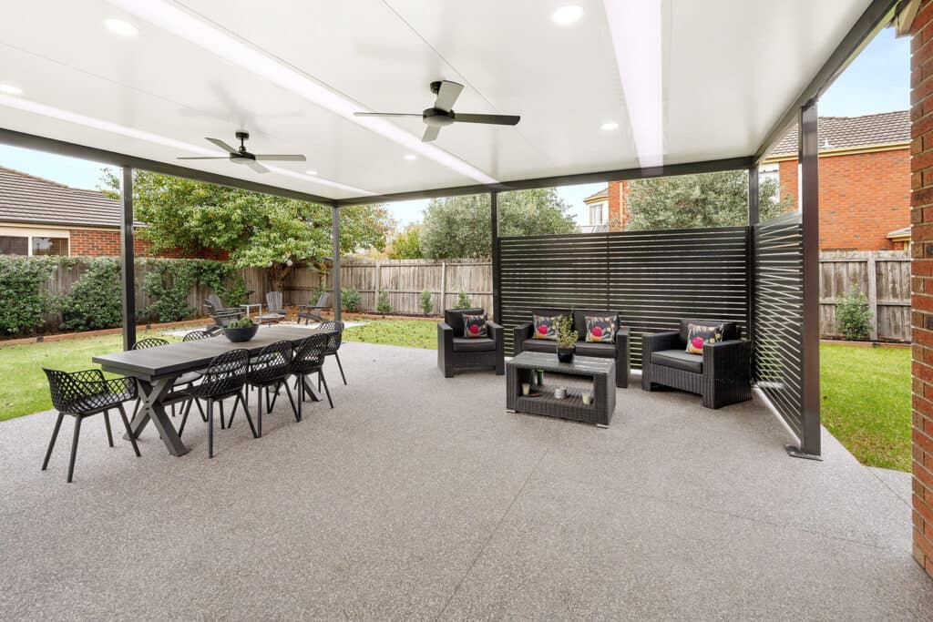 Insulated flat roof patio with ceiling fans and privacy screening