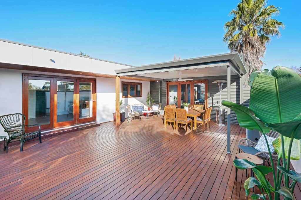 Decked outdoor living area with swimming pool with insulated roof